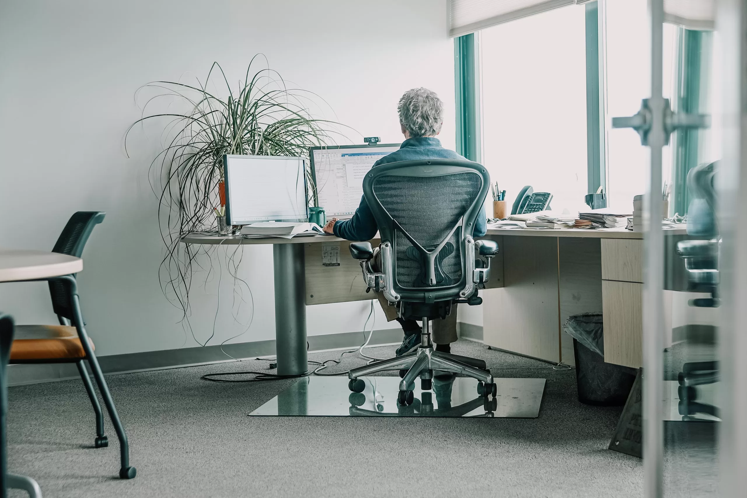 Man at a desk working on a computer in a modern office.